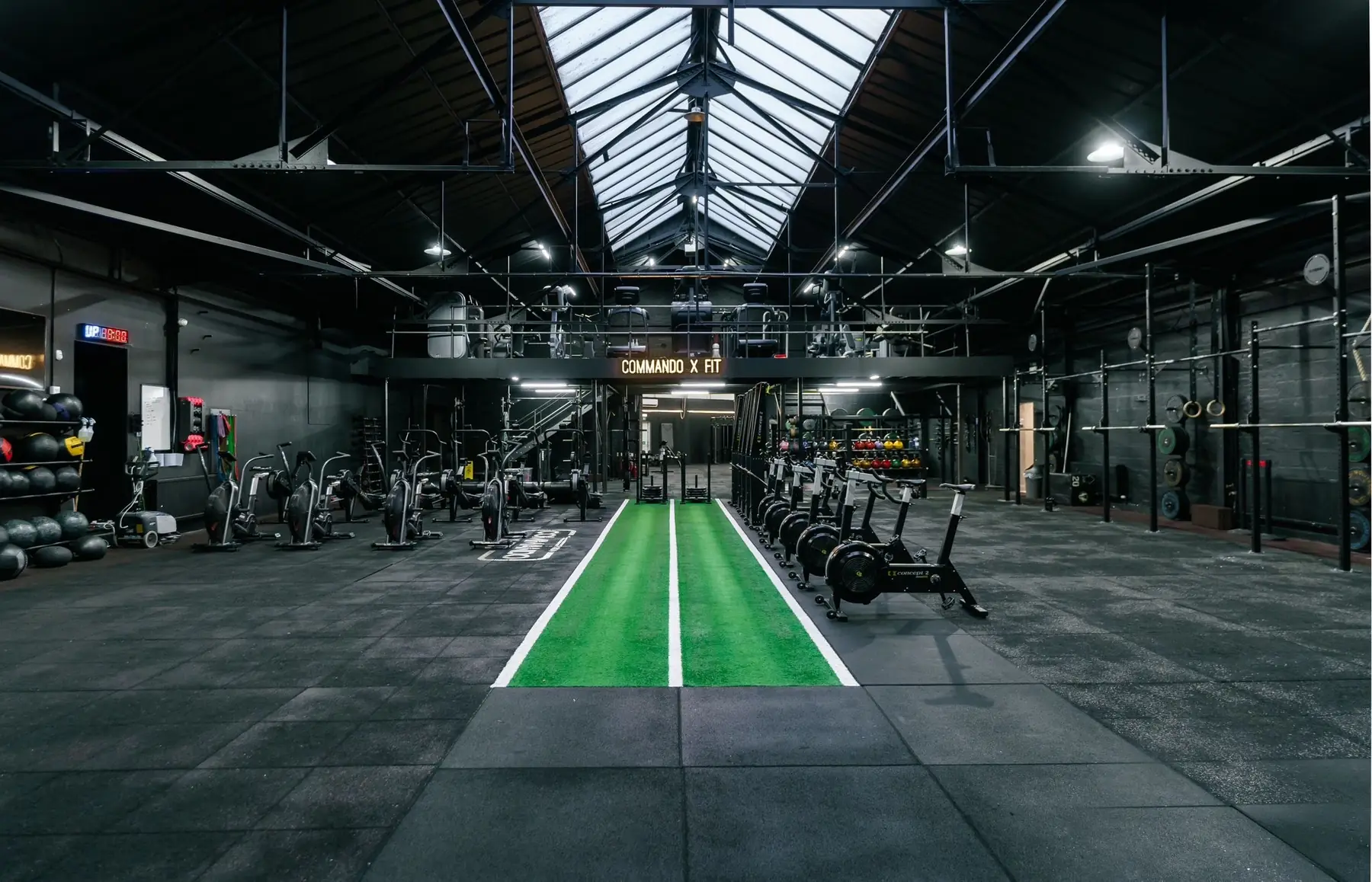 The main floor at Commando X-Fit in Hillington, with the turf track, racks and rowers