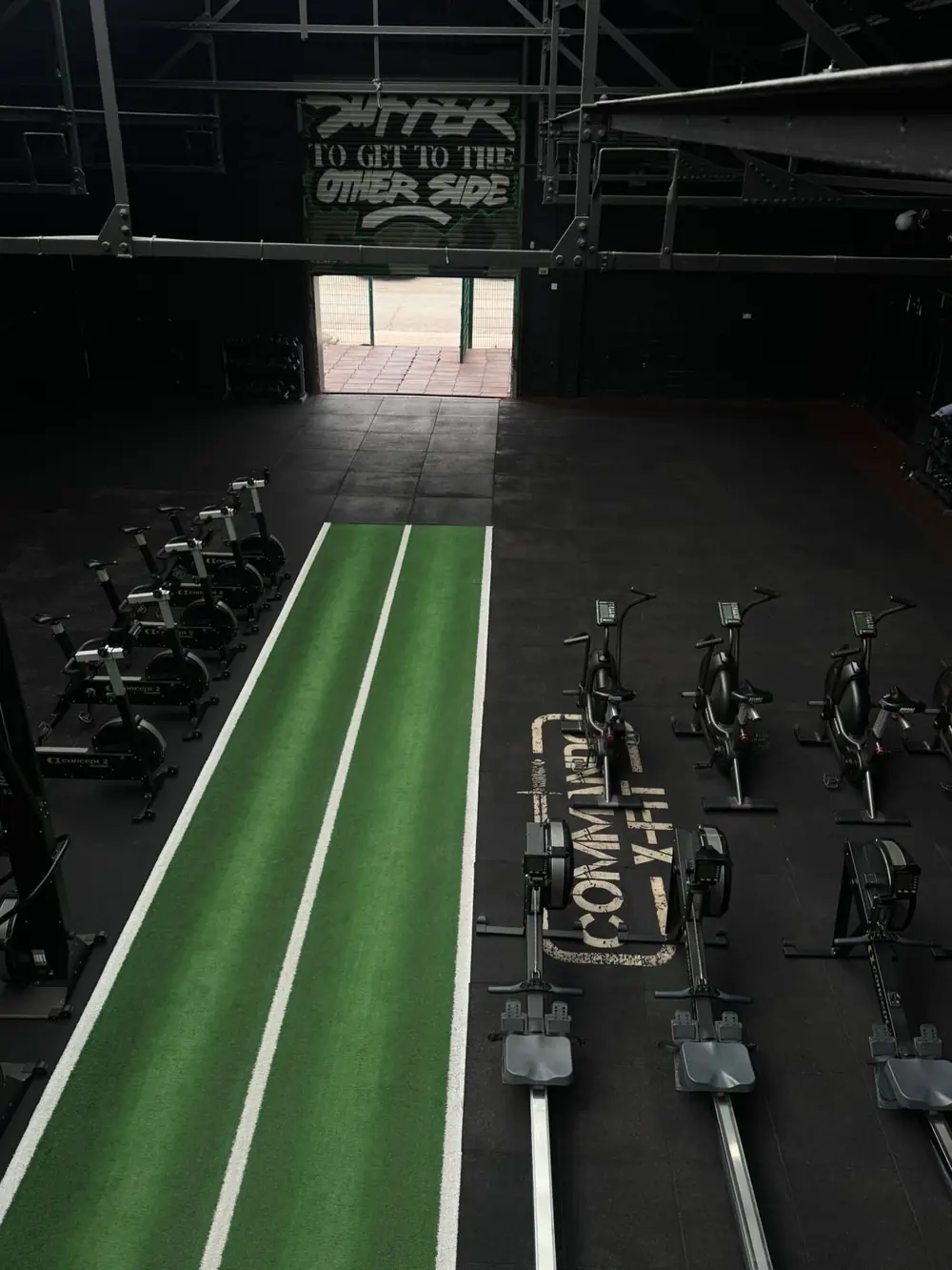 Looking down the turf track at Commando X-Fit, with rowers lined up alongside