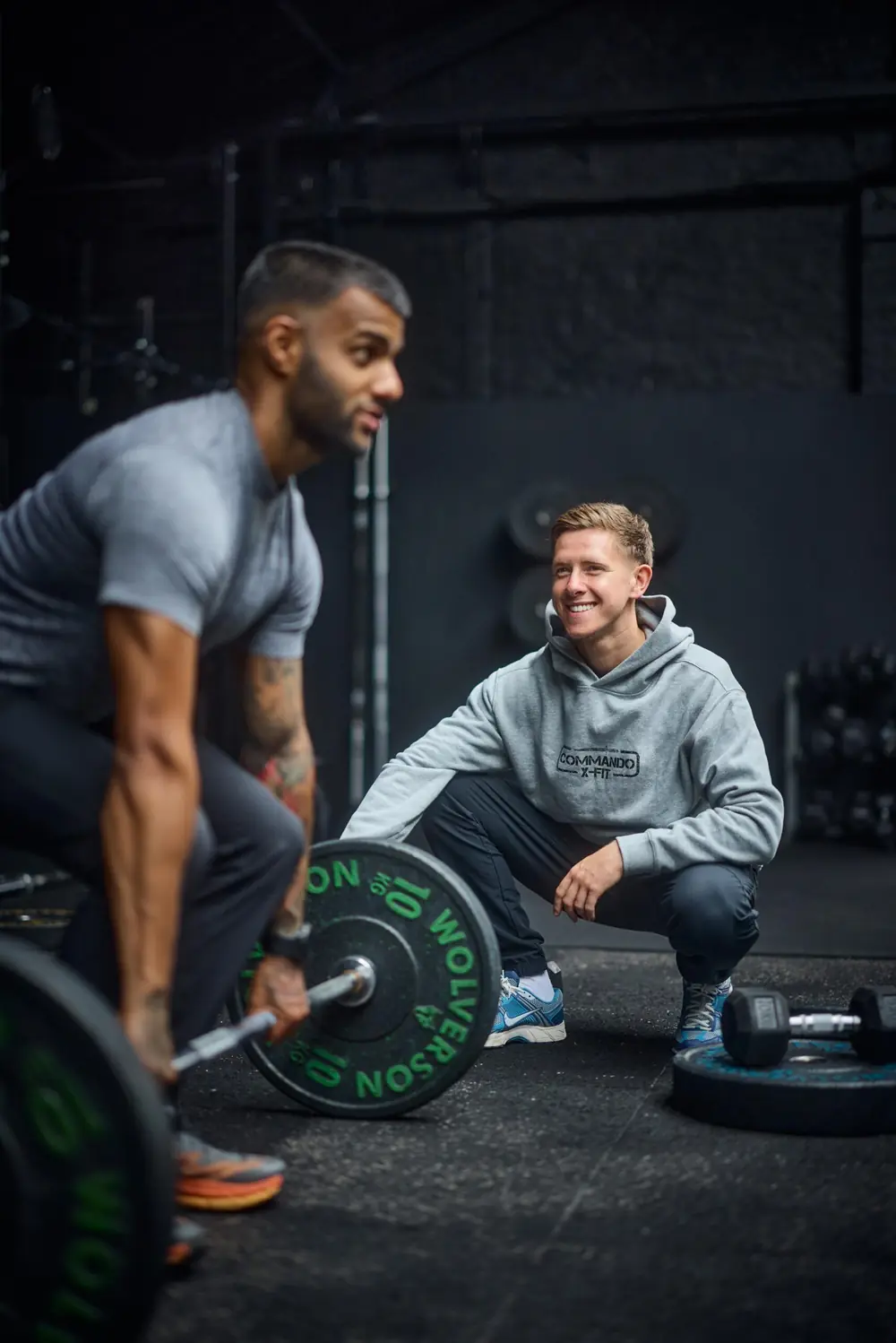A Commando X-Fit coach watching a client set up for a deadlift