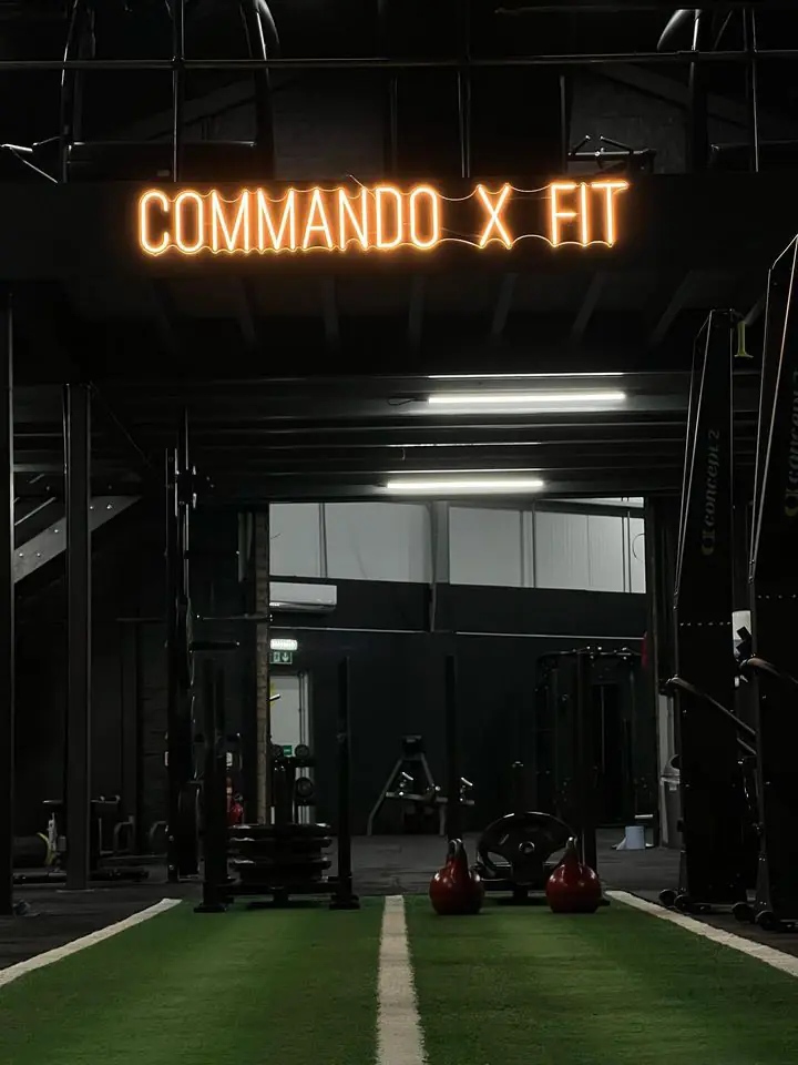 The amber Commando X-Fit sign over the turf track