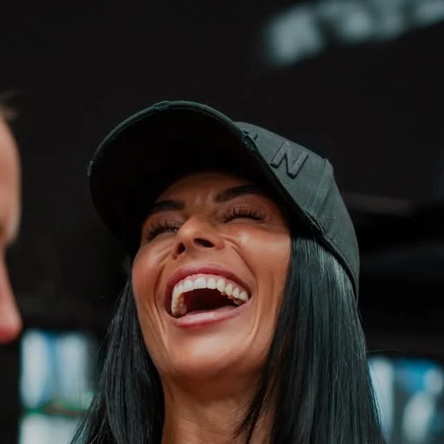 Lowri laughing in her black cap