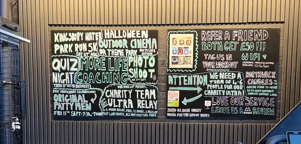 The chalk events board in the More Life Coaching studio listing a quiz night, a photo shoot, a park run and a charity team relay