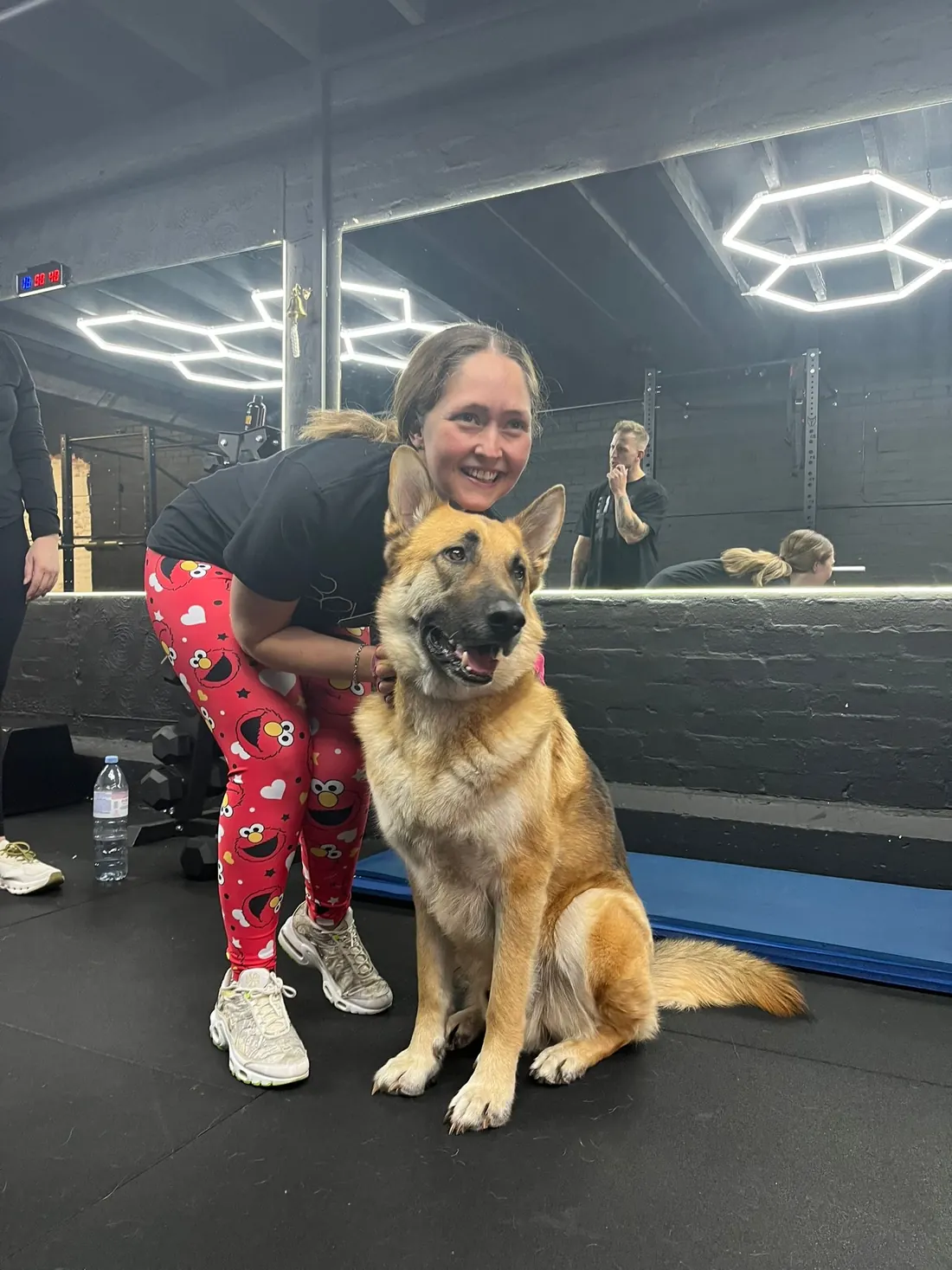 A More Life Coaching member with a German shepherd dog in the studio