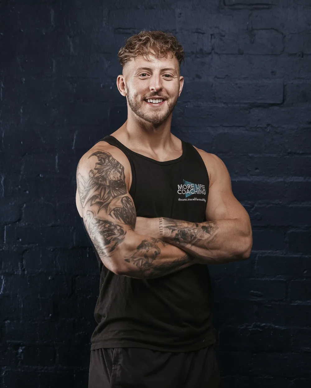 Scott, coach and co-owner of More Life Coaching in Sutton Coldfield, smiling with his arms folded